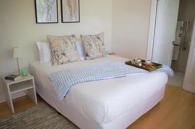 a bedroom with a white bed with a tray on it at Le Habitat 6 in Franschhoek