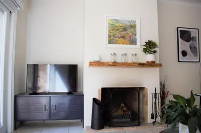 a living room with a television and a fireplace at Le Habitat 6 in Franschhoek