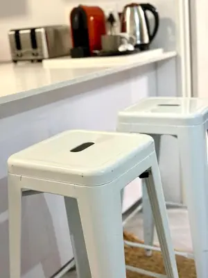 a white stool in front of a kitchen counter at Modern charm in Pinelands in Cape Town