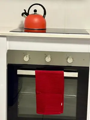 a red tea kettle sitting on top of an oven at Modern charm in Pinelands in Cape Town