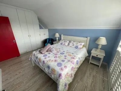 a small bedroom with a bed and two night stands at De Blauwvoet - Flamingo Apartment in Cape Town