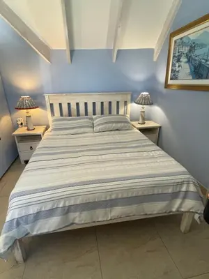 a bedroom with a large bed with two night stands at De Blauwvoet - Dolfyn (Sunset Beach) in Cape Town