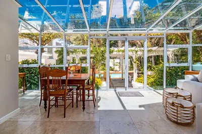 a dining room with a glass house with a table and chairs at The Atrium in Somerset West