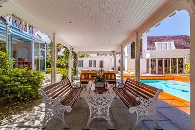 a porch with two benches and a swimming pool at The Atrium in Somerset West