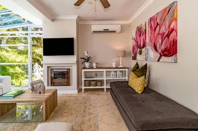 a living room with a couch and a tv at The Atrium in Somerset West