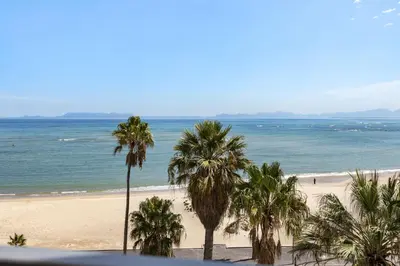 a view of a beach with palm trees and the ocean at Welgelegen 608 in Strand