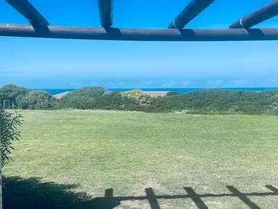 a view from a window of a green field at 241 hermanus beach club in Hermanus