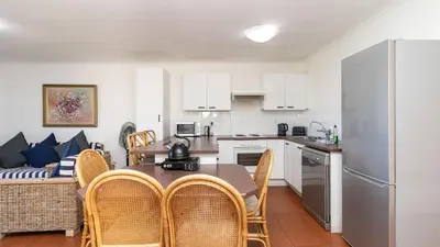 a kitchen and dining room with a table and chairs at 241 hermanus beach club in Hermanus
