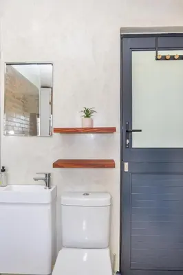 a bathroom with a toilet and a sink and a blue door at Blouberg Studio Apartments in Bloubergstrand