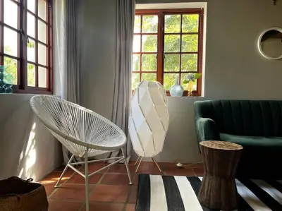 a living room with a chair and a couch at Comfy Greyton Cottage for Four in Greyton