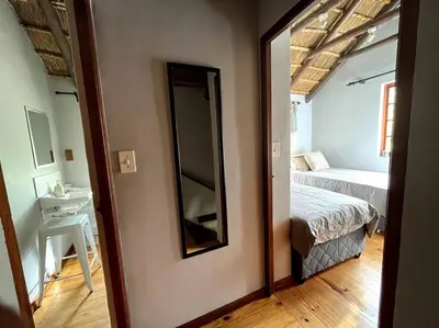 a bedroom with a mirror and a bed in a room at Comfy Greyton Cottage for Four in Greyton