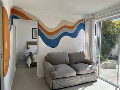 a living room with a couch and a bedroom at Coastal House - 2BR and Self catering in Cape Town
