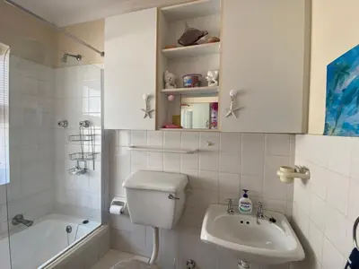 a bathroom with a toilet and a sink and a tub at Blouberg Cosy 2 bedroom house in Cape Town