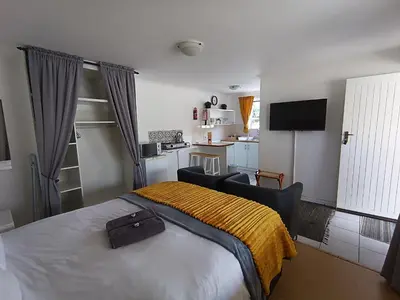 a bedroom with a bed with a brown blanket on it at NoulAnouk's Corner - Peaceful Studio in Cape Town