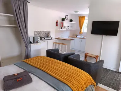 a kitchen with a table and chairs in a room at NoulAnouk's Corner - Peaceful Studio in Cape Town