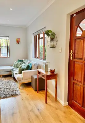 a living room with a couch and a table at Petit Casa Central Stellenbosch in Stellenbosch