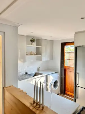 a kitchen with a sink and a washing machine at Petit Casa Central Stellenbosch in Stellenbosch