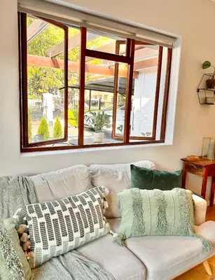 a living room with a couch and a window at Petit Casa Central Stellenbosch in Stellenbosch