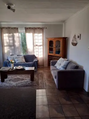 a living room with two couches and a coffee table at Streams Cottage in Bettyʼs Bay