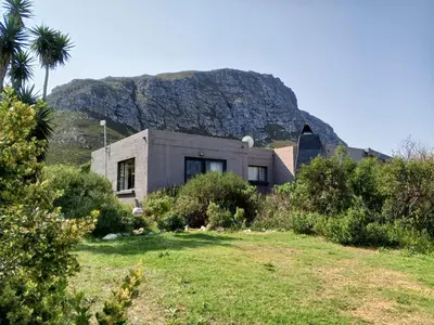 a house with a mountain in the background at Streams Cottage in Bettyʼs Bay