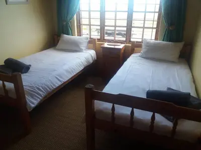 two beds in a room with a window at Witteklip self-catering farm in Kleinmond