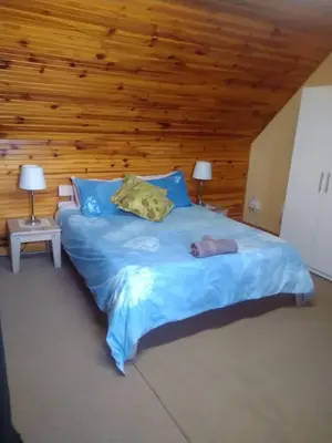 a large bed in a room with a wooden ceiling at Witteklip self-catering farm in Kleinmond