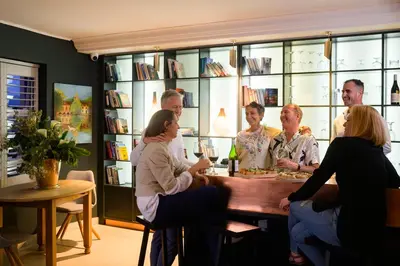 a group of people sitting around a table in a room at Fijnbos Private Manor in Gordonʼs Bay