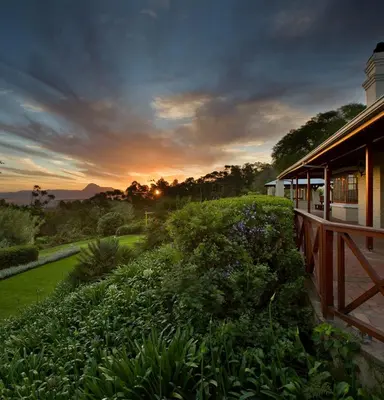 a sunset over a house with a garden at The Caledon Hotel and Spa in Caledon