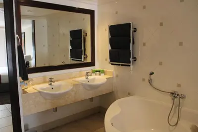 a bathroom with two sinks and a tub and a mirror at The Caledon Hotel and Spa in Caledon