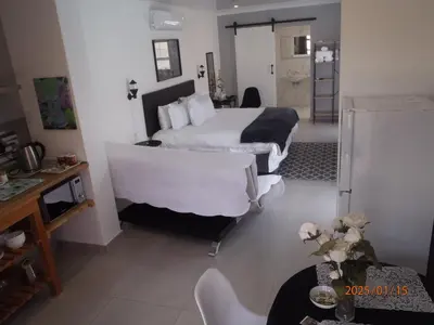 a hotel room with two beds and a bathroom at Mi Amor Accommodation in Brackenfell
