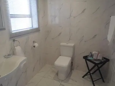 a white bathroom with a toilet and a sink at Mi Amor Accommodation in Brackenfell