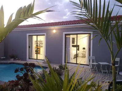 a villa with a swimming pool and a house at Mi Amor Accommodation in Brackenfell