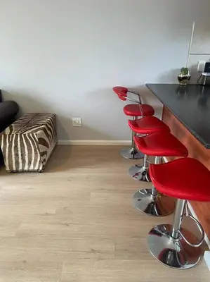 a room with a bar with red stools in it at Mini Suits in Cape Town