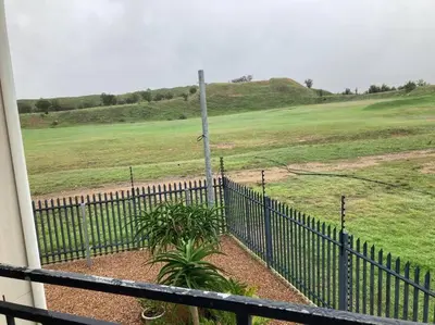 a fence in front of a field with a pole at Mini Suits in Cape Town