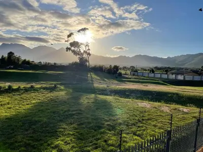 a field with a fence and a tree in the distance at Mini Suits in Cape Town