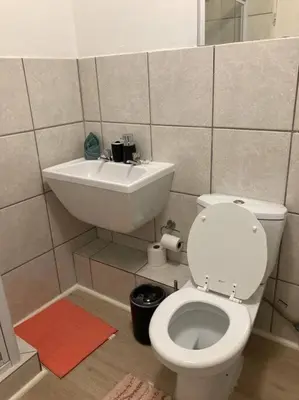 a bathroom with a white toilet and a sink at Mini Suits in Cape Town
