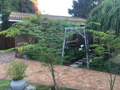 a garden with a tree and a fence at Aan de weg in Cape Town