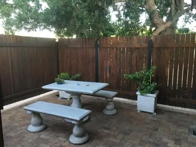a picnic table with two benches in front of a fence at Aan de weg in Cape Town