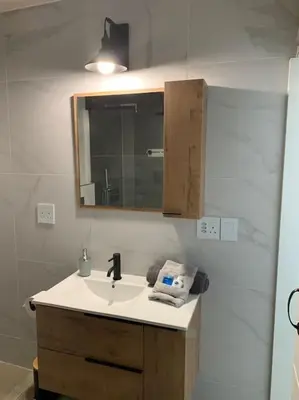 a bathroom with a sink and a mirror at Maîté Iphupho in Somerset West
