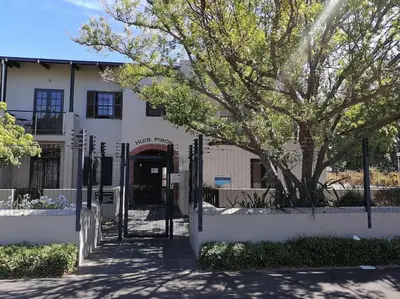 a building with a gate and a tree in front of it at The Lookout Loft, a short stroll into town in Stellenbosch