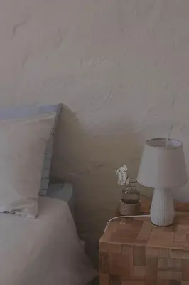 a bed with a table with a lamp on it at Three Streams Cottages in Franschhoek