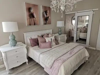 a bedroom with a bed with pink pillows and a mirror at Ocean and mountain breeze in Hermanus