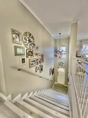 a staircase in a home with pictures on the wall at Ocean and mountain breeze in Hermanus