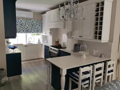 a kitchen with white cabinets and a chandelier at Ocean and mountain breeze in Hermanus