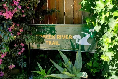 a green sign in a garden of flowers at The Rondebosch on Belmont in Cape Town