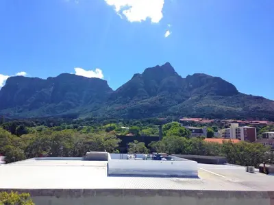 a building with mountains in the background at The Rondebosch on Belmont in Cape Town