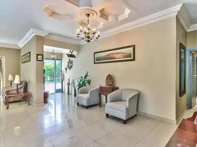 a living room with two chairs and a chandelier at Villa Jesdene in Cape Town