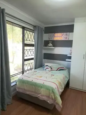 a small bedroom with a bed and a window at Cosy and Central Family Home in Cape Town
