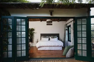 a bedroom with a bed and sliding glass doors at Tollbosch in Somerset West
