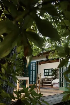 a house with a wooden deck with a stove at Tollbosch in Somerset West